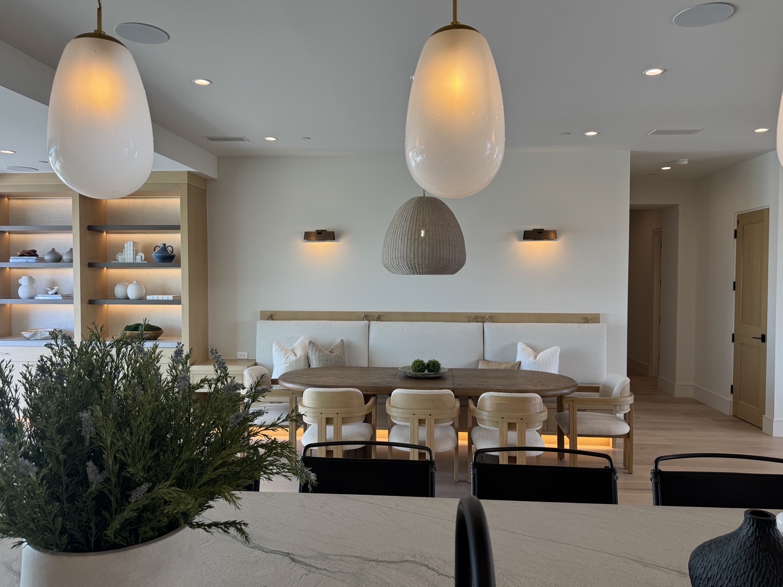 Dining area with decorative pendants, wall sconces and illuminated cabinetry
