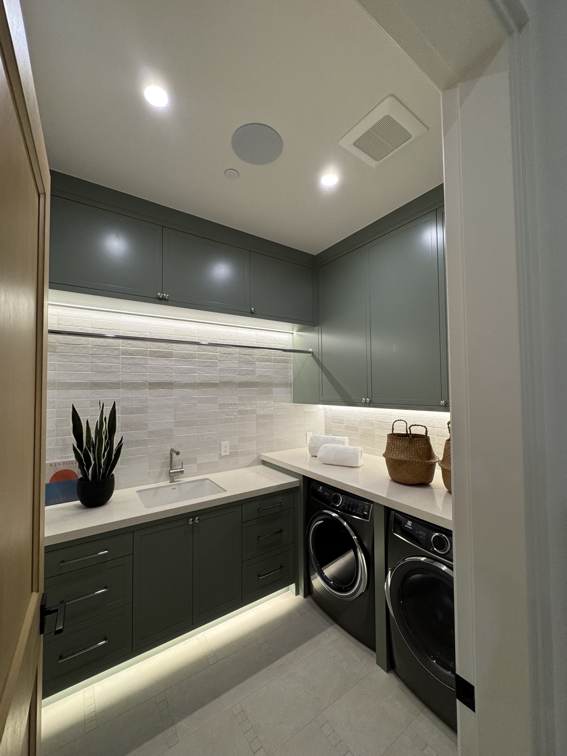 Custom laundry room with under-cabinet task light and illuminated toe kick